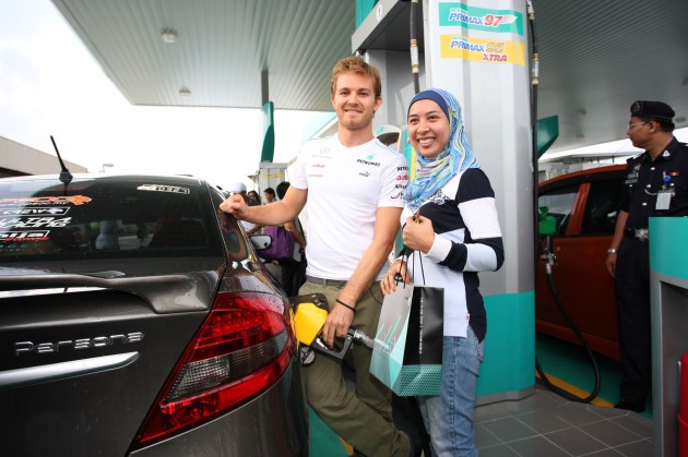 Nico Rosberg 1 Mercedes GP F1 driver Nico Rosberg refuels lucky customers’ cars at Petronas’ 1,001st station